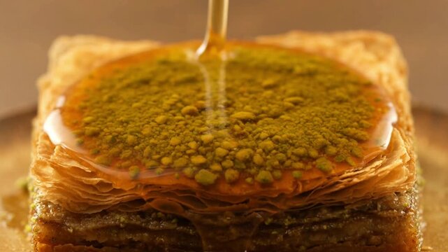 Sweet Baklava Delight - Honey Pouring Over Pistachio Topped Pastry.