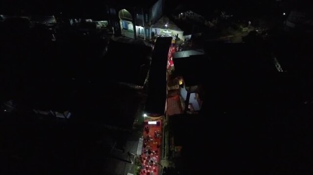 4K Aerial View of a Vibrant Indonesian Village Community Gathering at Night.