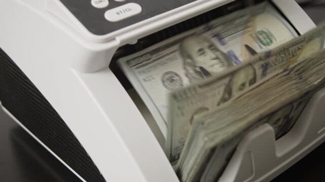 Hundred dollar bills moving through counting machine. Money counting processing. Hundred dollar banknotes motion in counting machine. American dollars in cash counter. USD bills.