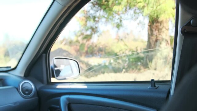 Inside view of car interior raising and lowering side window with electric control, smooth glass movement in modern SUV door panel, everyday driving comfort feature, automotive technology in action