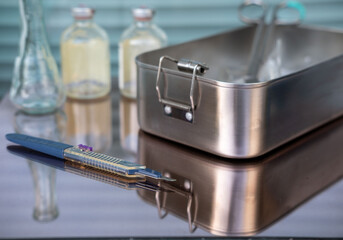 Naklejka premium Stainless steel tray, medical instruments, syringes, sterile preparation, surgical tools, post-procedure cleanup, clinical setting, infection control, healthcare waste, professional medical practice