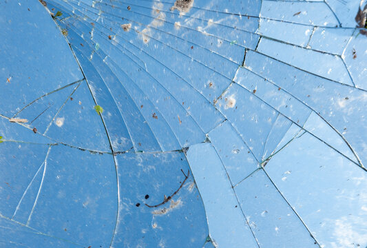 Broken mirror, shattered texture of broken mirror, glass, dangerous debris, Accidental damage, sharp fragments, safety hazard, luck and superstitions background
