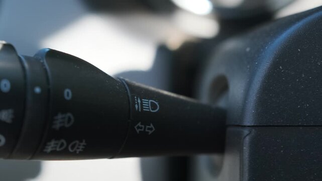 Car high beam control lever switching on headlights, close-up of steering column stalk in SUV interior, lighting system activation, driving safety feature, automotive control night visibility function