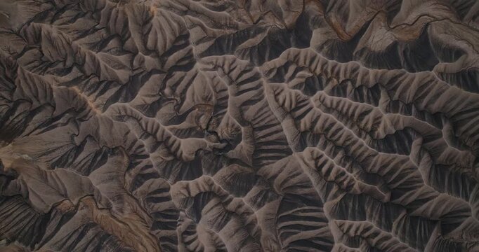 Deeply carved desert badlands ridges and erosion channels in Utah near Factory Butte, drone