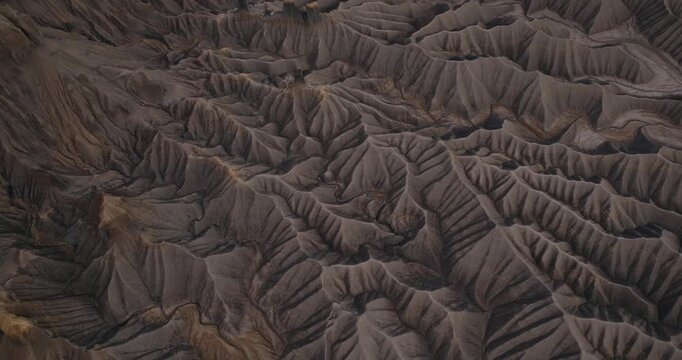 Shadowed desert badlands ridges forming textured erosion patterns near Factory Butte Utah, drone
