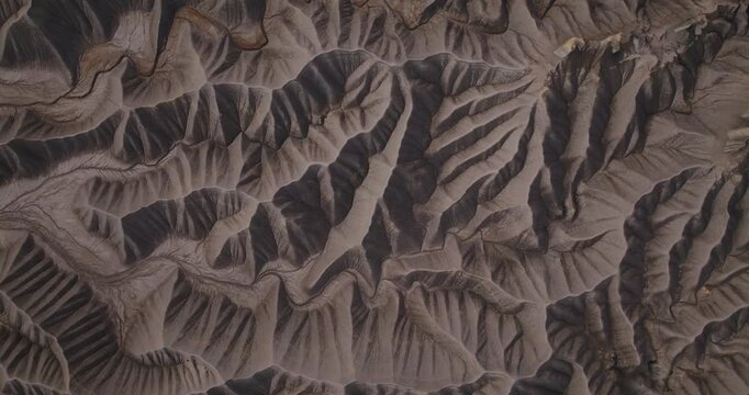 Layered desert badlands ridges forming complex erosion patterns near Factory Butte Utah, drone