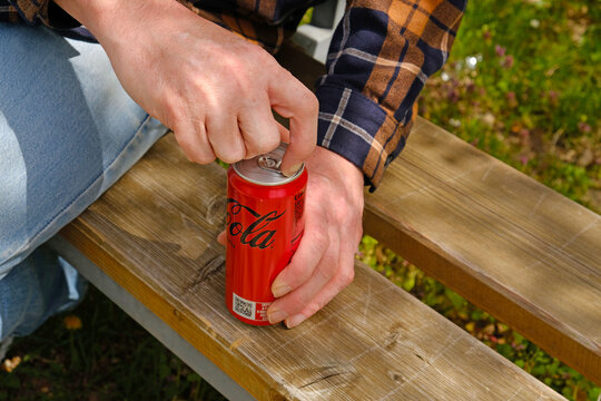 Person opens Coca-Cola Zero Sugar aluminium can. For beverage advertising, lifestyle branding, and casual outdoor campaigns. Prague - April 28, 2026.