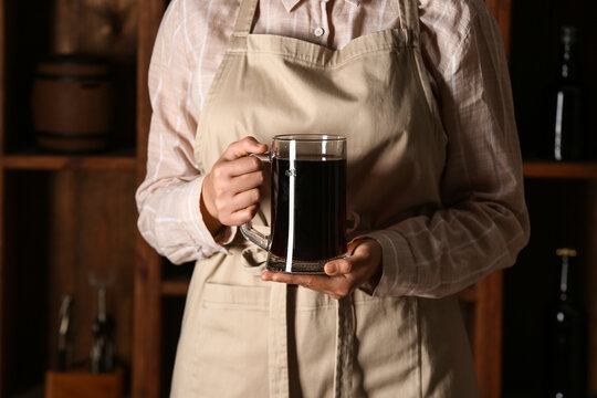 Woman with mug of tasty kvass in storage