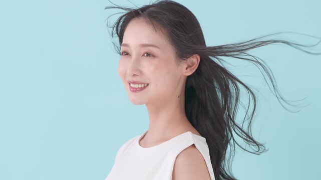 女性　ブルーバック　髪　風
