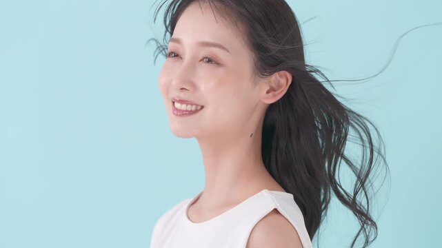 女性　ブルーバック　髪　風