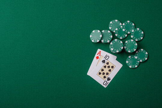 Playing cards and chips on a green cloth, a gambling game of blackjack or baccarat. Cards and chips