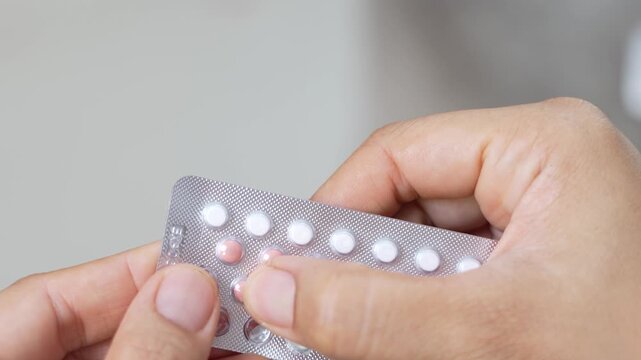 Close up woman hand contraceptive pill. Contraception reduces childbirth and pregnancy concept.