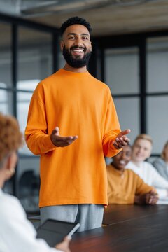 Young man presenting to team in modern conference room