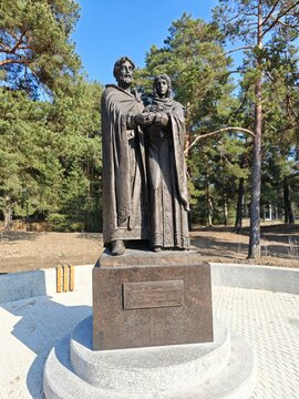 Sosnoviy Bor, Russia - March 30, 2026: Peter and Fevronia of Murom, saints, Bronze statue of historical figures in traditional attire holding hands, surrounded by trees in a park setting