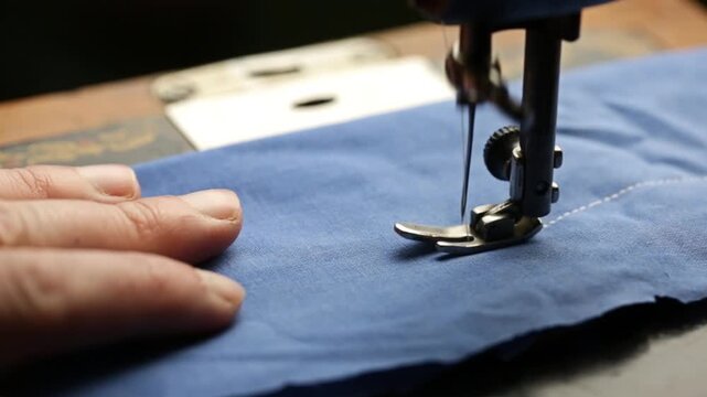 A seamstress works on a vintage sewing machine, sewing at home