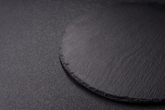 A blank slate board on a dark background for Asian food. A blank slate board