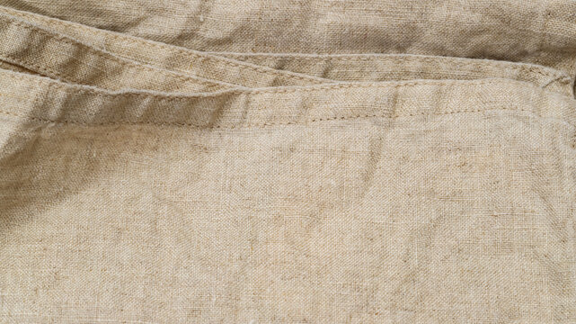 Natural fabric texture shows folds and seams in a light-colored cloth from an unknown location at an unspecified time