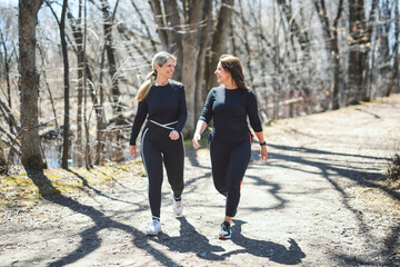 Naklejka premium Energetic middle-aged woman jogs through a tree-lined path