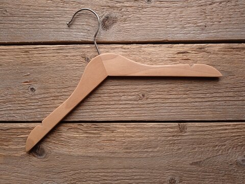 Top view of a small wooden clothes hanger on an old wooden table.