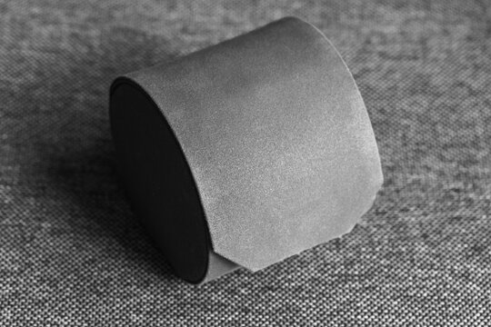 Velvet-covered round jewelry box sits on a textured fabric surface in a high-contrast black and white close-up, evoking luxury, gift giving, minimal design and product photography