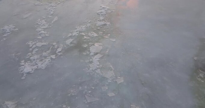 Large frozen river at sunset view from the sky, flight over frozen river in winter