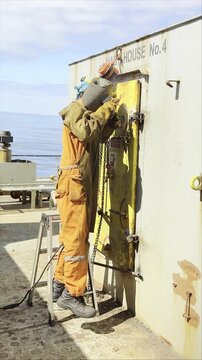 ship fitter make repairing of water tight door of the cargo vessel. welding operations. hand job. seafarers