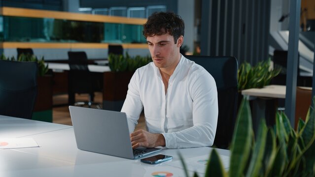 Focused Caucasian business man thinking working with laptop online work think job businessman guy male typing browsing computer internet technology cyberspace concentrated agent specialist in office