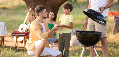 Happy family at barbecue party on summer day