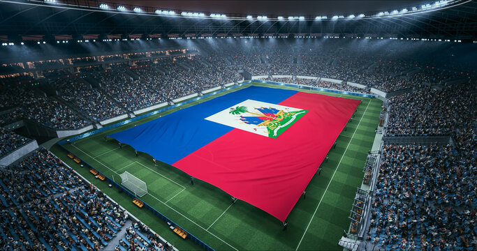 Professional Stadium Soccer Game Championship With Flag of Haiti Spread Across the Pitch Before Football Match Start. Cheering Crowds of Fans Surround the Field. Aerial Wide Shot