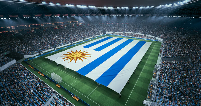 Professional Stadium Soccer Game Championship With Flag of Uruguay Spread Across the Pitch Before Football Match Start. Cheering Crowds of Fans Surround the Field. Aerial Wide Shot