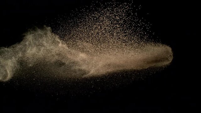 Super Slow Motion Shot Flying Soil Isolated on Black at 1000fps.