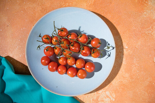 Tiny cherry tomatoes ciliegini, pachino, cocktail. group of cherry tomatoes on a color concrete background.