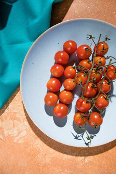 Tiny cherry tomatoes ciliegini, pachino, cocktail. group of cherry tomatoes on a color concrete background.