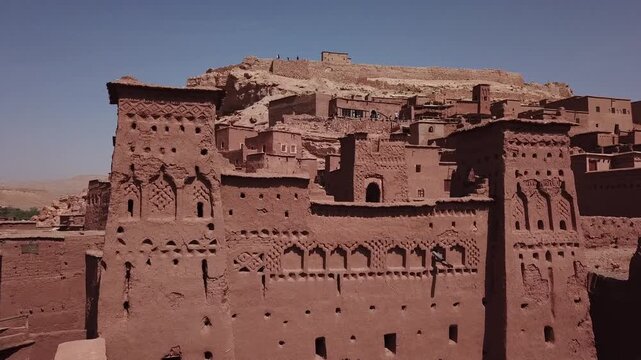 Detailed view of an ornate Moroccan kasbah facade in Ouarzazate featuring traditional adobe patterns and decorative elements. Rich cultural architecture ideal for heritage and design visuals.