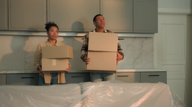 Two home owners African american couple feeling stress eviction trouble sad man and woman with packed cardboard boxes repair dwelling moving day family relocation misery displeased financial crisis