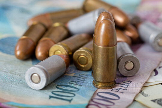 Botswana Pula Banknotes with Standing 9mm Pistol Ammunition lying scattered across the currency.