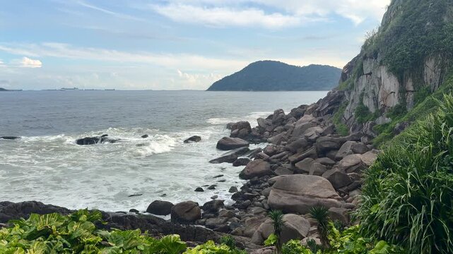Scenic view of the Atlantic Ocean waves crashing against the rocky shoreline at Mirante das Galhetas in Guaruj&aacute;, Brazil.