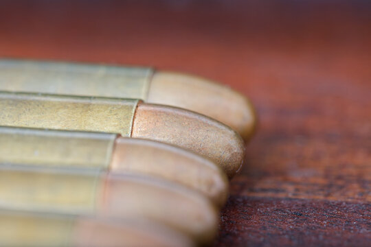 Close-up Macro of 9mm Handgun Ammunition cartridges lined up in a Row copper-plated tips