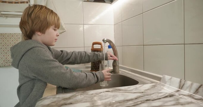 Kid Boy Drinks Glass of Water in Kitchen. 4K 10-bit