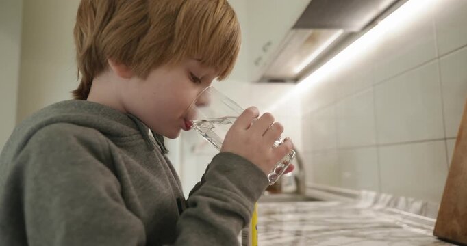 Kid Boy Drinks Glass of Water in Kitchen. 4K 10-bit