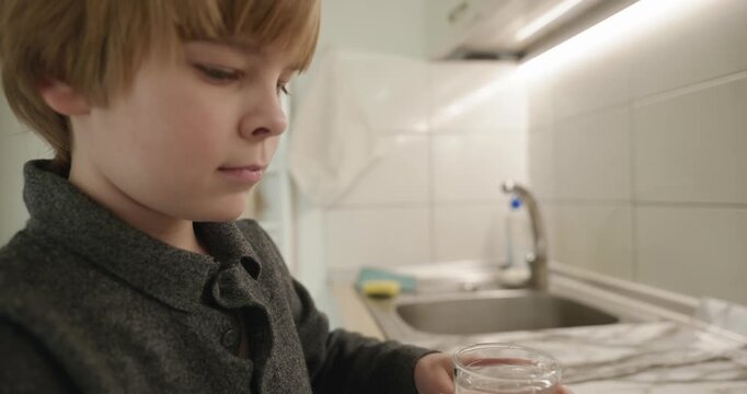 Kid Boy Drinks Glass of Water in Kitchen. 4K 10-bit