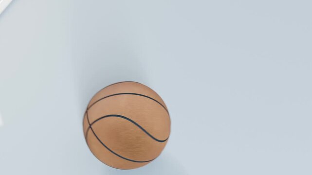 Refocusing camera showing basketball emerging from hole onto pale-blue panel, near white highlight