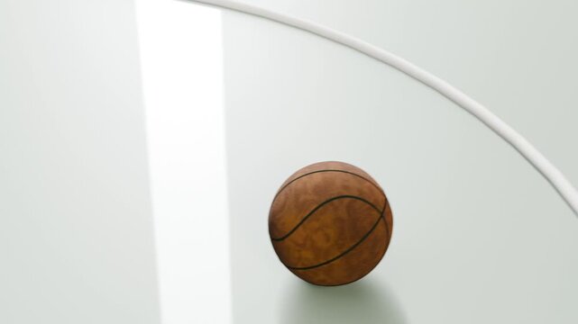 Dropping brown leather basketball bouncing on glossy pale court panel, passing white curved rail