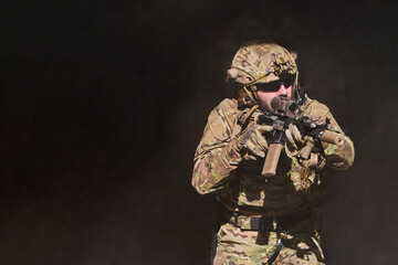 Obraz premium Camouflaged Soldier With Rifle in Tactical Gear Aiming During Military Training or Operation