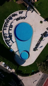 Aerial view of teardrop-shaped outdoor pool and sun loungers. Cascais, Portugal