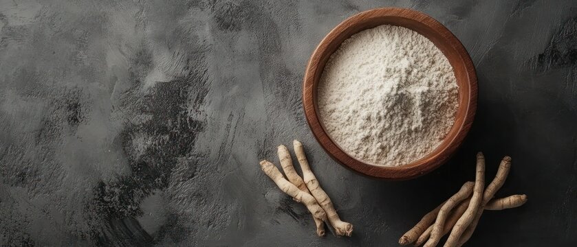 Wooden bowl of light colored powder and beige roots on dark textured surface