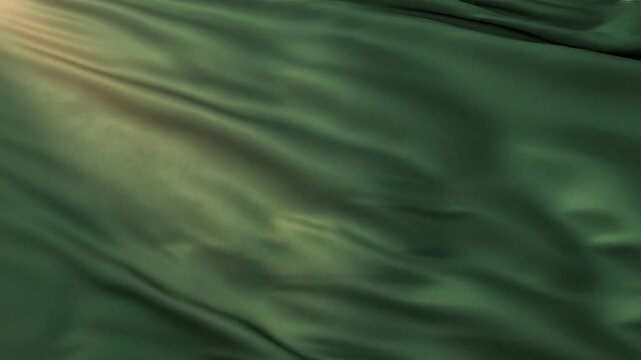 Deep green satin fabric draped with soft folds and illuminated by gentle light rays creating a and texture
