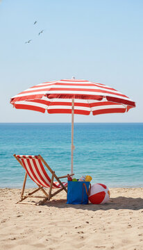 A beach chair and striped umbrella sit on sand by the ocean, with a beach bag and ball, symbolizing summer vacation and relaxation