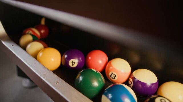 Close up on pool balls dropping out of return system on billiard table, copy space