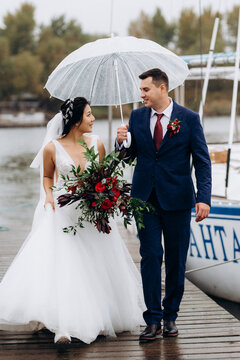 young couple, the bride and groom, walking along a pier